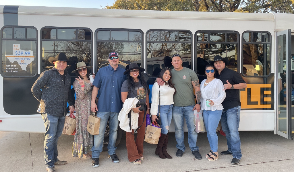 a group of people in front of the 290 Wine Shuttle in Fredericksburg, Texas