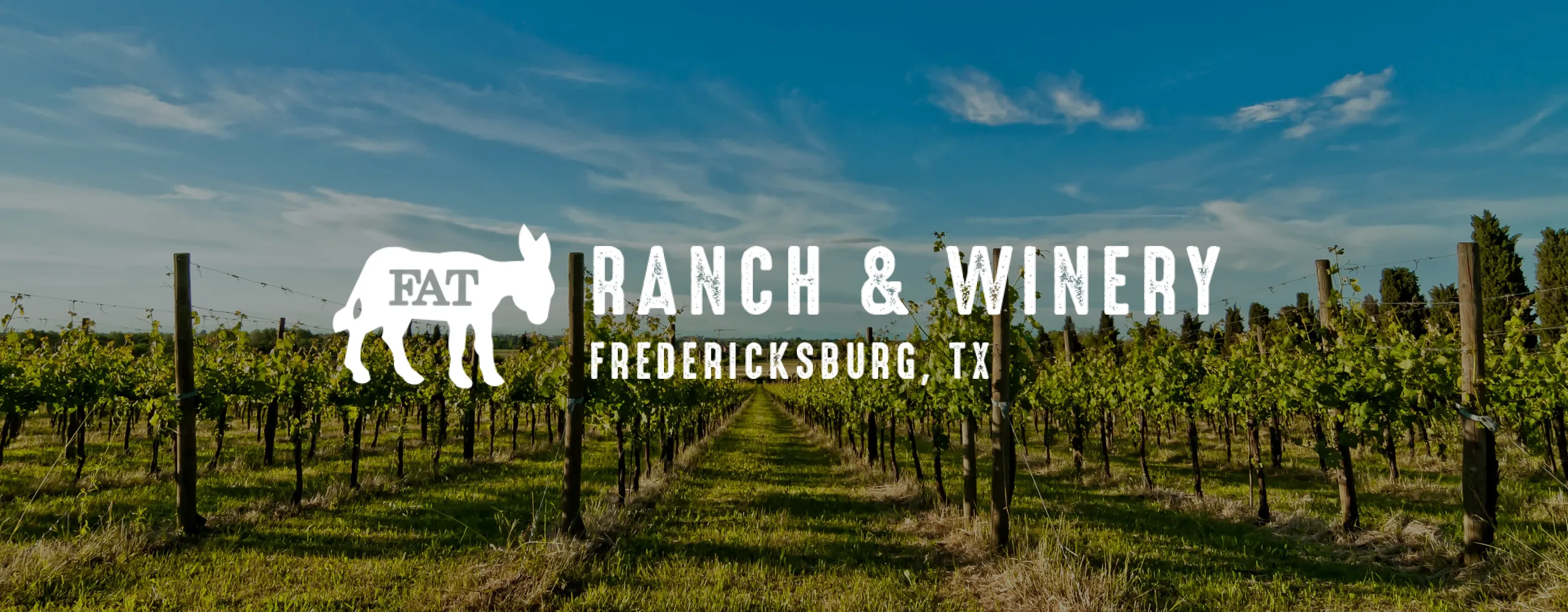 Fat Ass Ranch & Winery Logo overlaid on a photo of a vineyard.