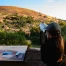 A young woman wearing a ball cap looks at scenery in Fredericksburg, Texas.